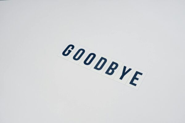 Word Goodbye on White Surface